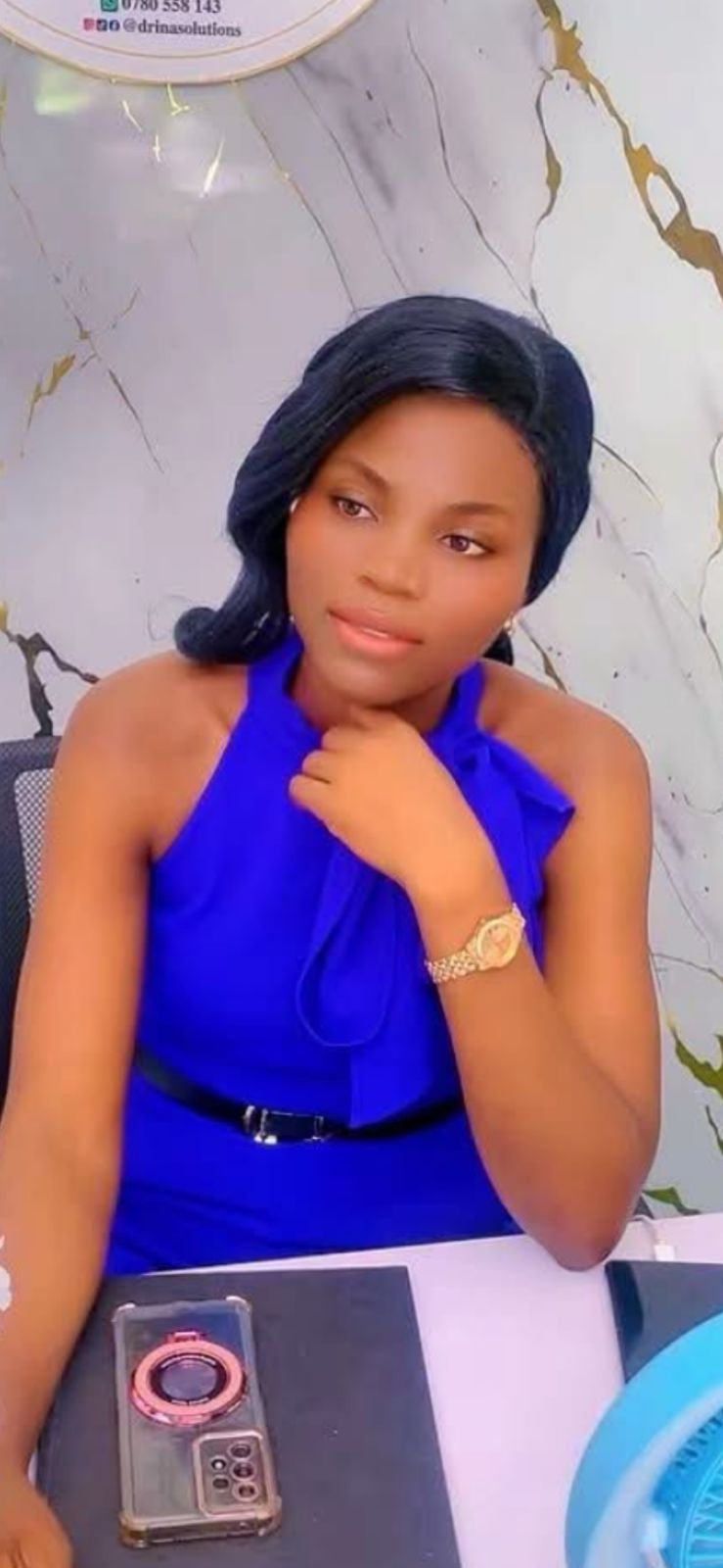 The owner of DRINA SOLUTIONS wearing an elegant blue dress